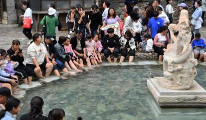 圖為游客在溫泉扎堆泡腳。